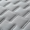 Close-up of light gray quilted fabric with a diamond pattern.