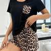 A woman models a black leopard print summer pajama set top and shorts.