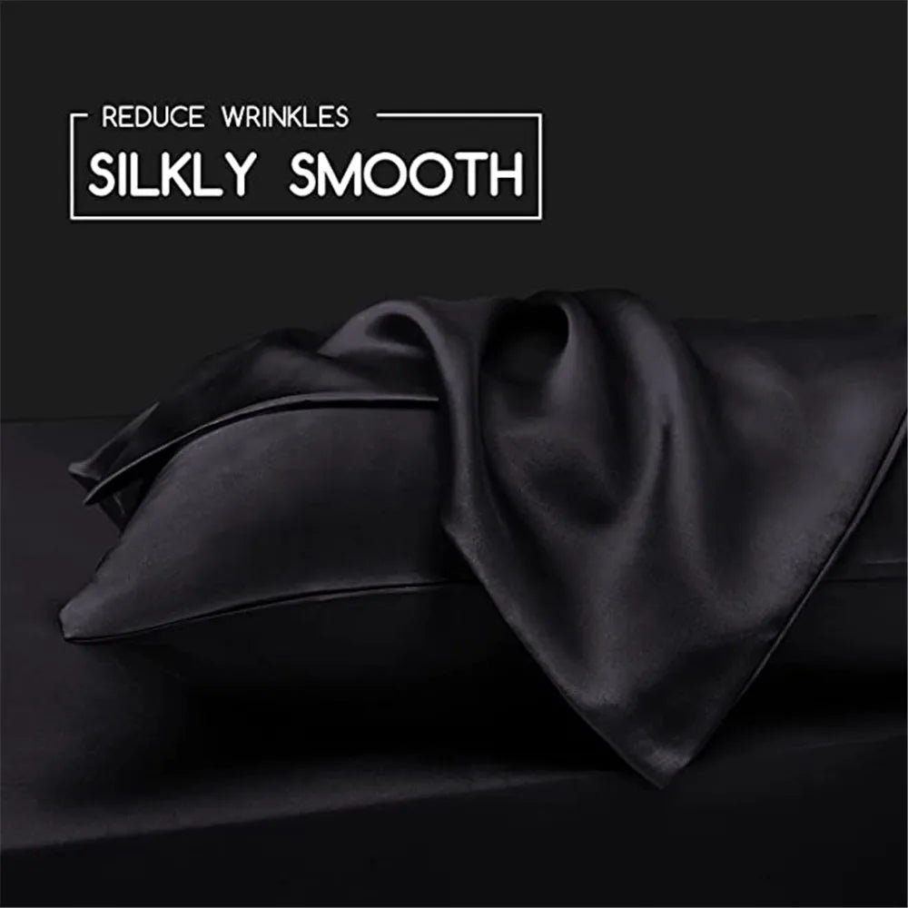 Black silky smooth satin fabric draped on a dark surface for pillow covers.