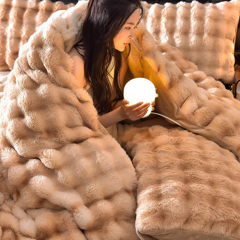 A woman is relaxing under a large, fluffy beige rabbit hair bedding set while holding a glowing light.