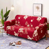 A deep red floral patterned sofa and chair slipcover displayed on a light purple rug.