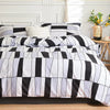A black and white marble print duvet cover set with pillows displayed on a bed.