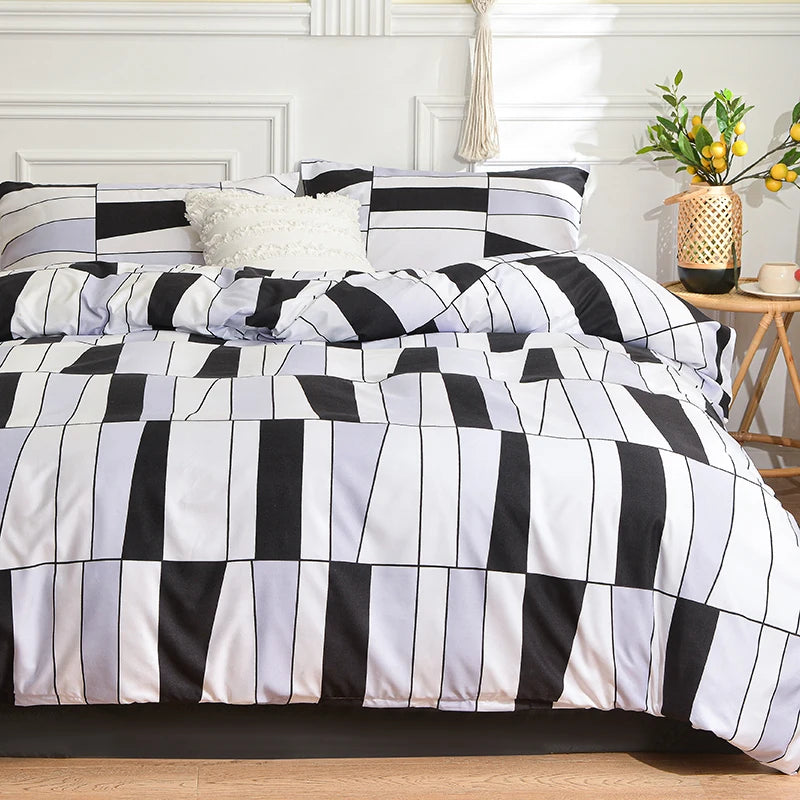 A black and white marble print duvet cover set with pillows displayed on a bed.