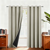Light beige blackout thermal window drapes hanging in a window frame.