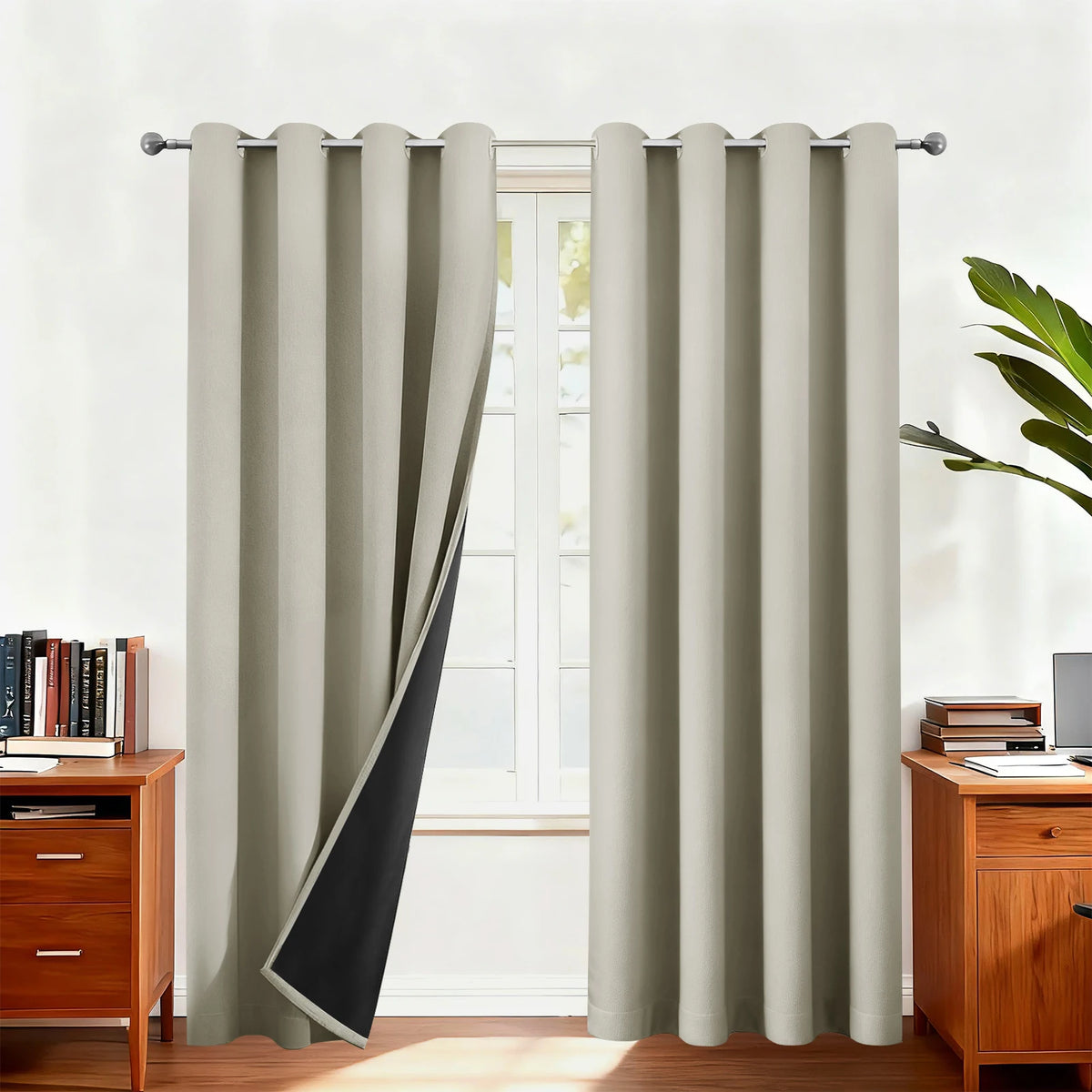 Light beige blackout thermal window drapes hanging in a window frame.