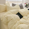 A bed with a white duvet cover set and pillows, featuring light beige and gray tones.