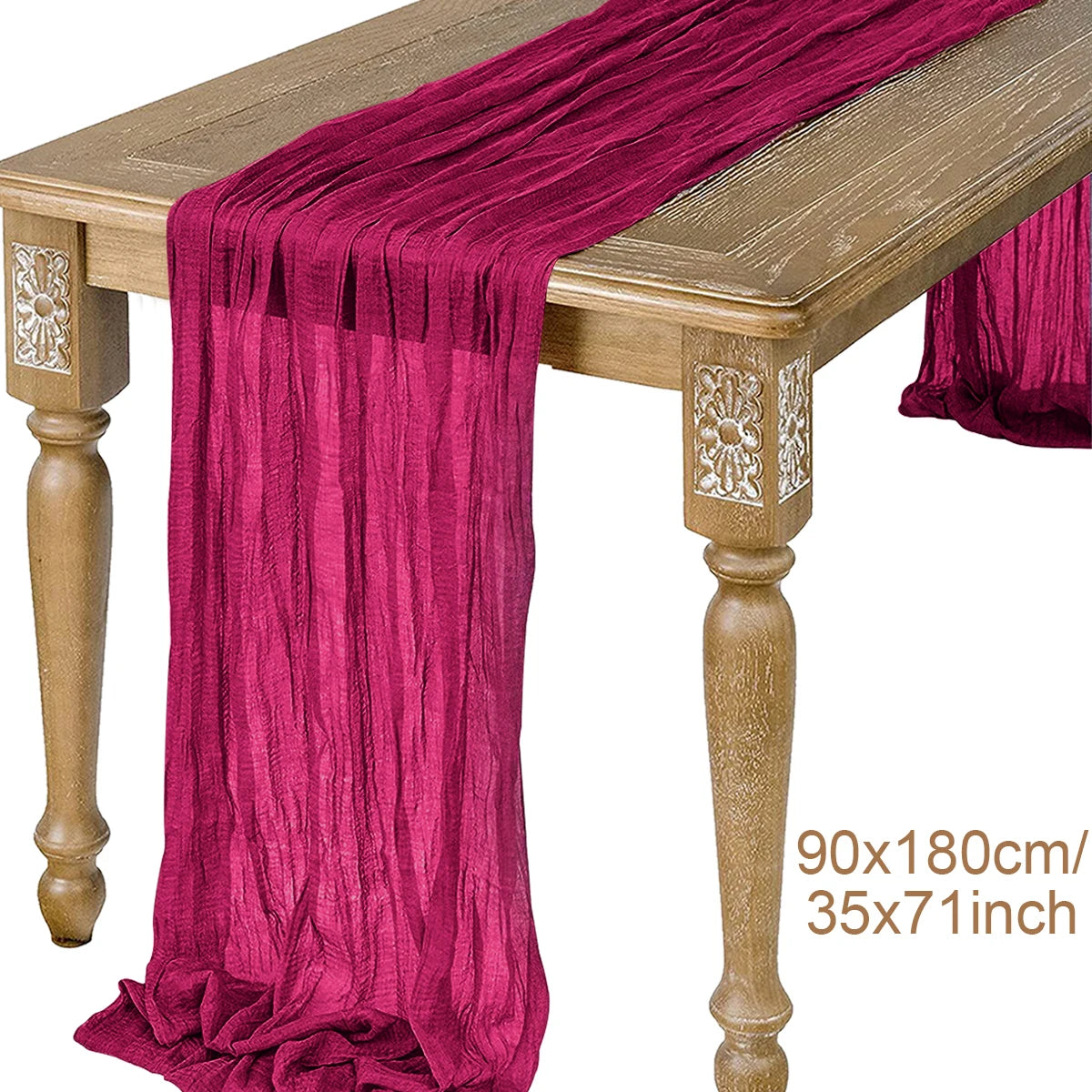 A deep magenta semi-sheer gauze table runner draped over a wooden table.