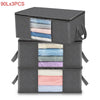 Three stacked gray storage boxes containing folded clothing or blankets