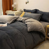 A dark gray luxurious flannel duvet cover set is displayed on a bed with yellow accents and natural light.