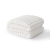 A stack of white striped flannel throw blankets folded neatly on a surface.