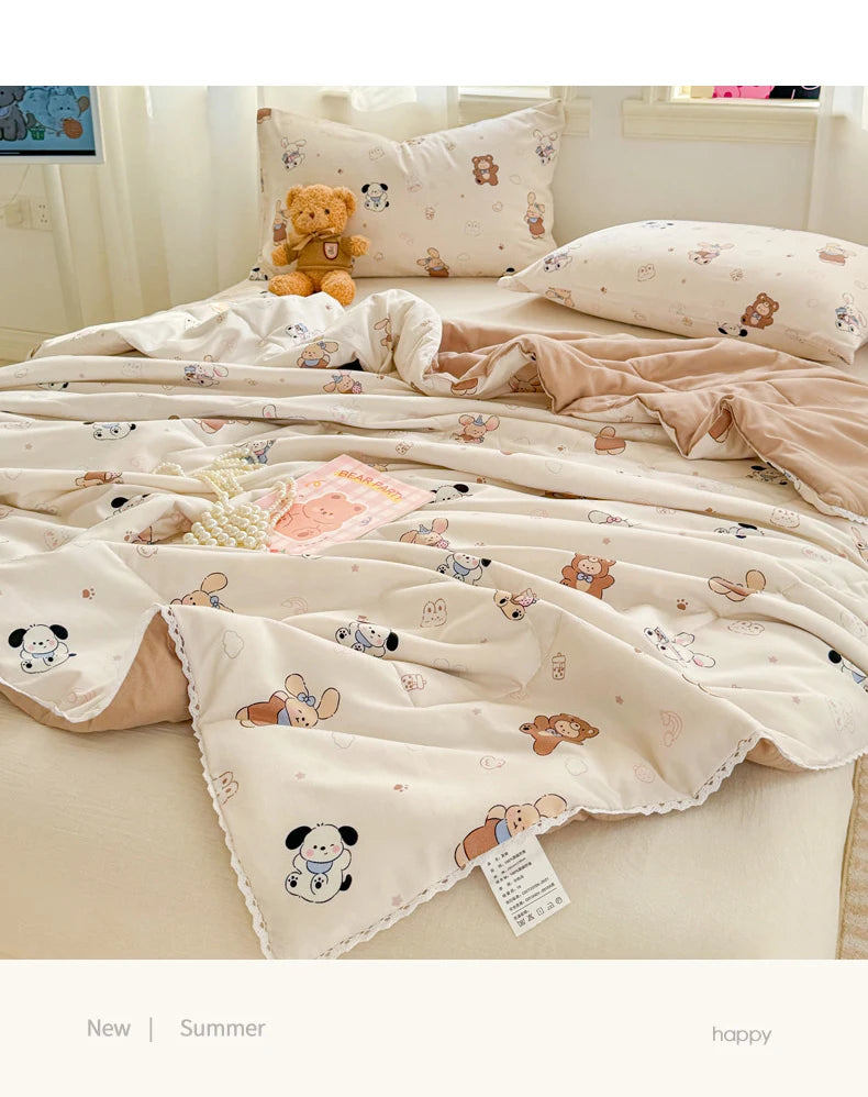 A light beige quilted blanket with a pattern of small animals and a teddy bear is displayed on a bed.