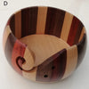 A wooden yarn bowl with striped patterns for crochet and knitting organization.