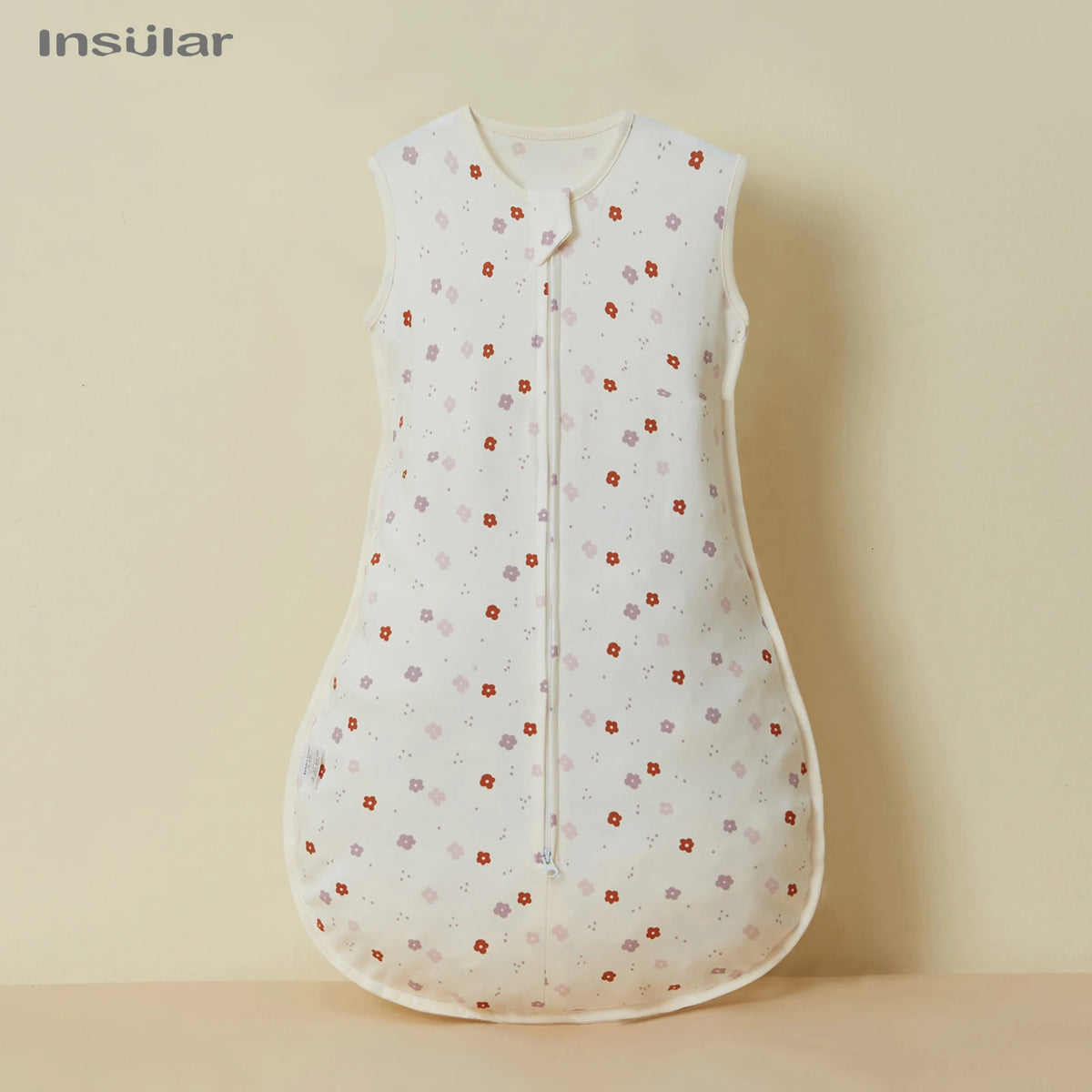 A white cotton sleep sack for baby or toddler with a floral pattern.