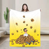 A yellow throw blanket featuring a cartoon character and scattered food items.