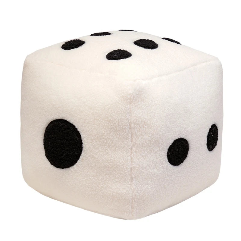 A white, soft plush pillow shaped like a large polka-dot die with black spots.