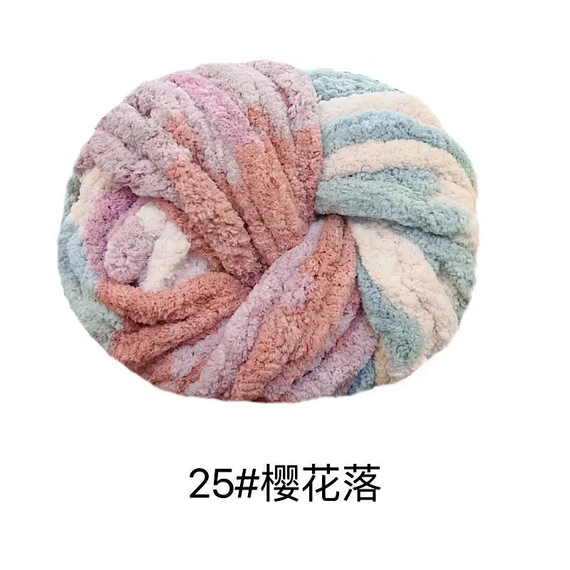 A ball of hand-woven chunky chenille yarn in pastel pink, blue, and cream colors.