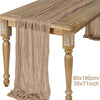 A beige semi-sheer gauze table runner draped over a wooden table with decorative legs.