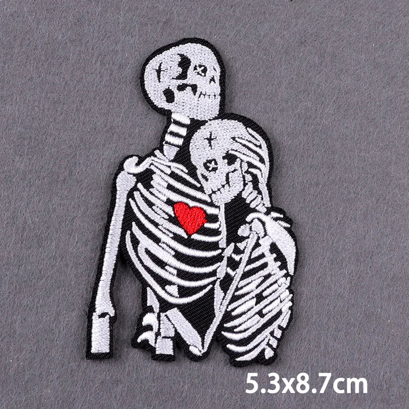 Black and white embroidered skull design featuring two skulls with a red heart between them on a patch