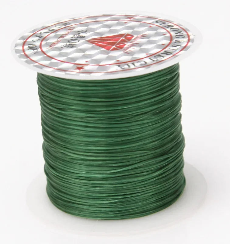 A spool of green elastic beading cord with a white label featuring a red diamond design and text.