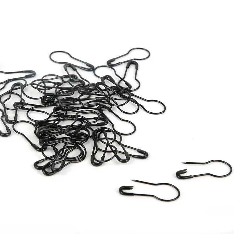 A tangled bundle of black safety bulb pins for knitting and sewing.