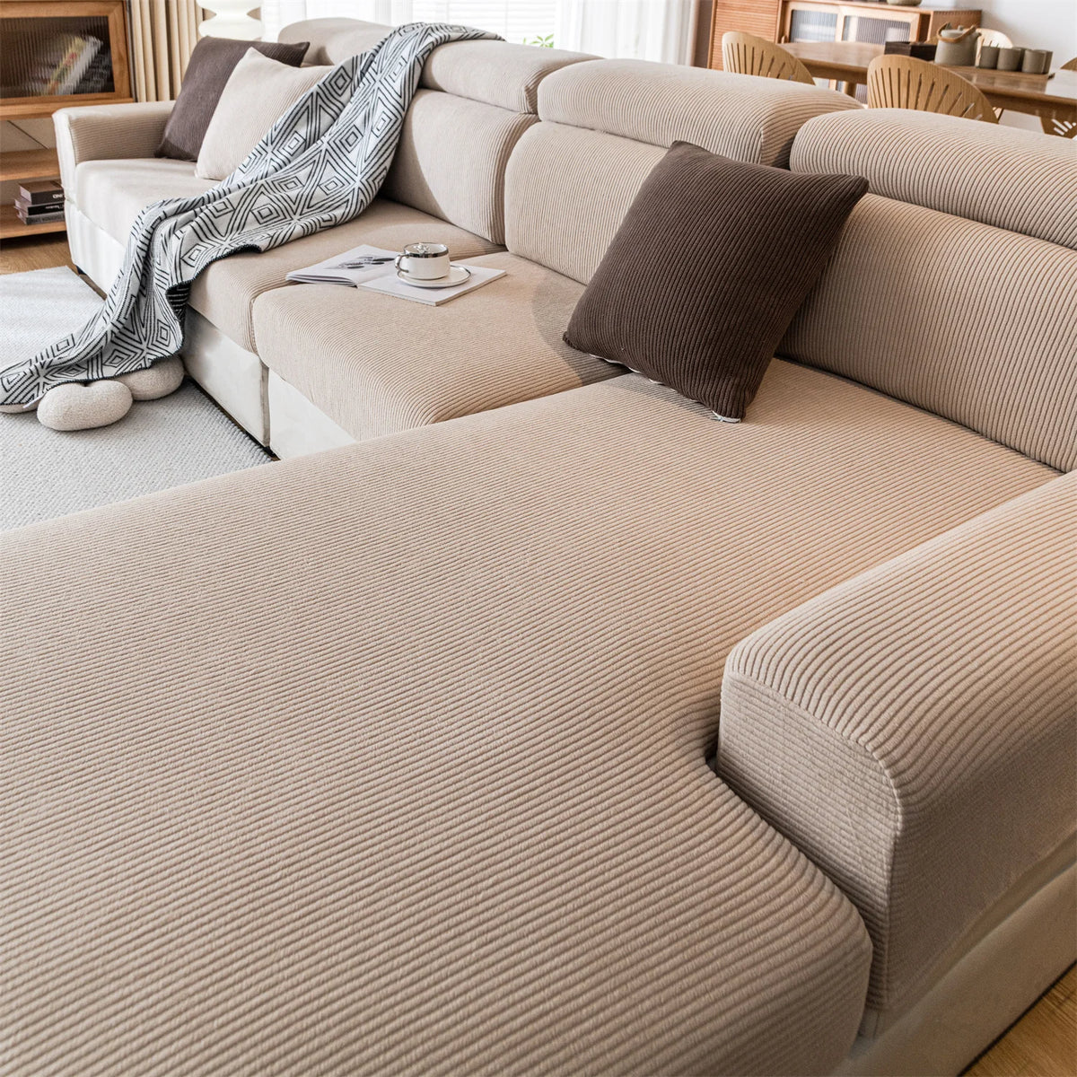 A beige removable jacquard seat cushion cover on a light-colored sofa with brown accent pillows.