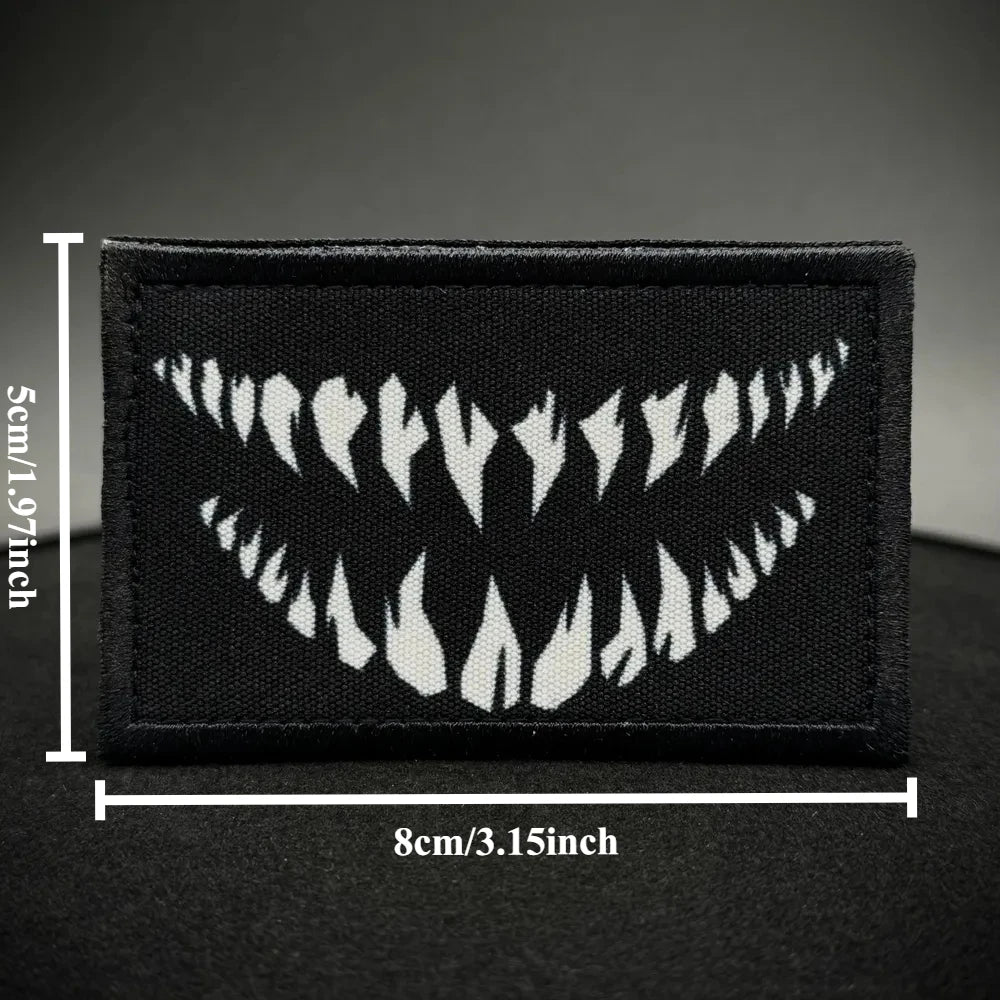Black tactical hook and loop emblem patches featuring a white tooth pattern.