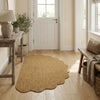 A natural jute non-slip entrance door mat placed on a light wood floor next to a white door and wooden furniture.