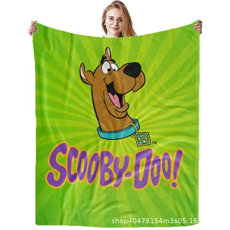 A green fabric throw blanket featuring a cartoon illustration of Scooby-Doo with a happy expression.