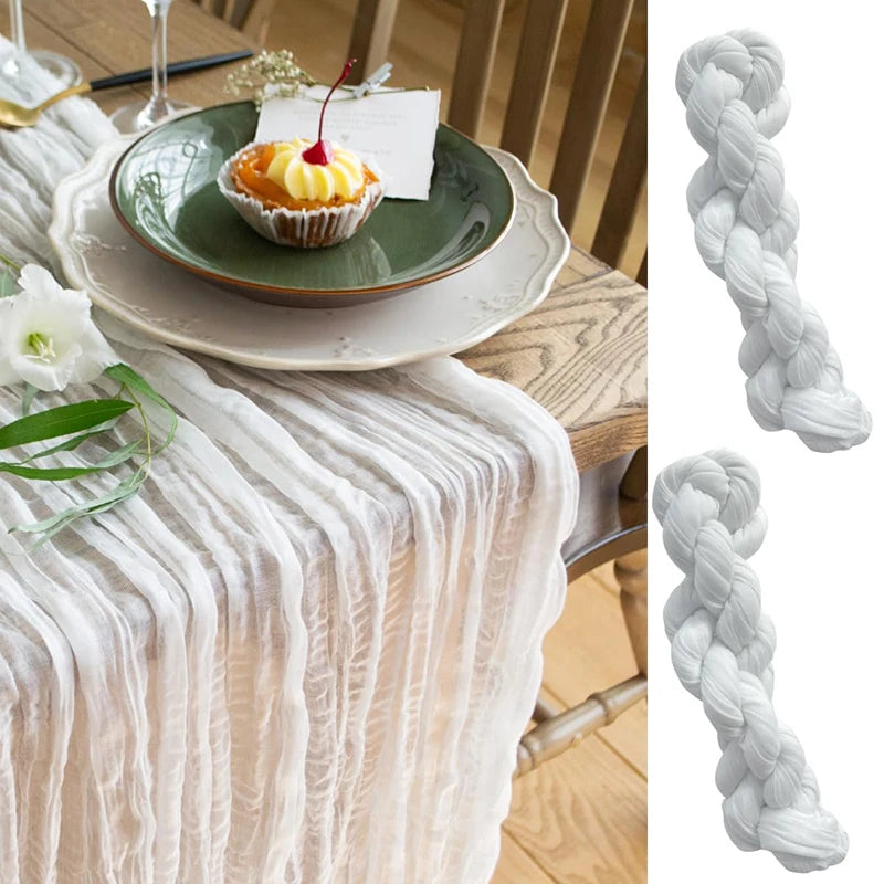 White cheesecloth table runner draped over a wooden table with a dessert plate and decorative twine