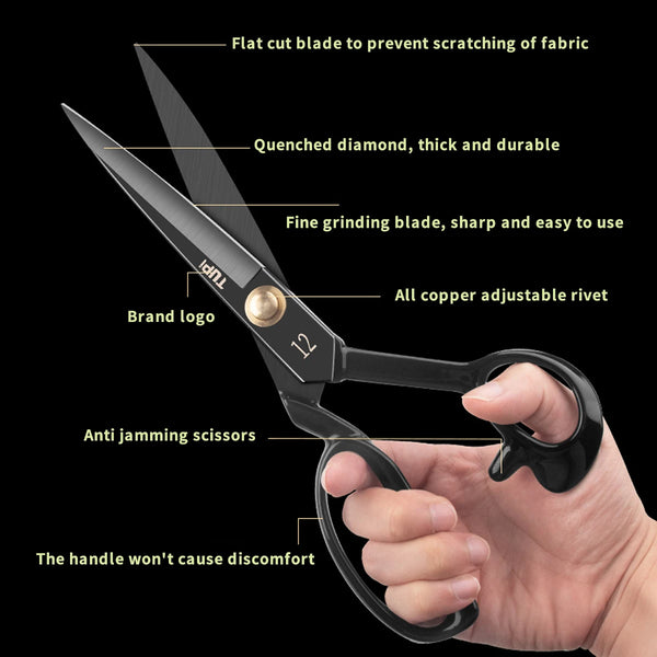 A pair of black professional tailoring shears with a flat cut blade and copper rivet being held in a hand.