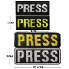 Four embroidered press patches in black, yellow, and white with hook and loop backing shown side by side.