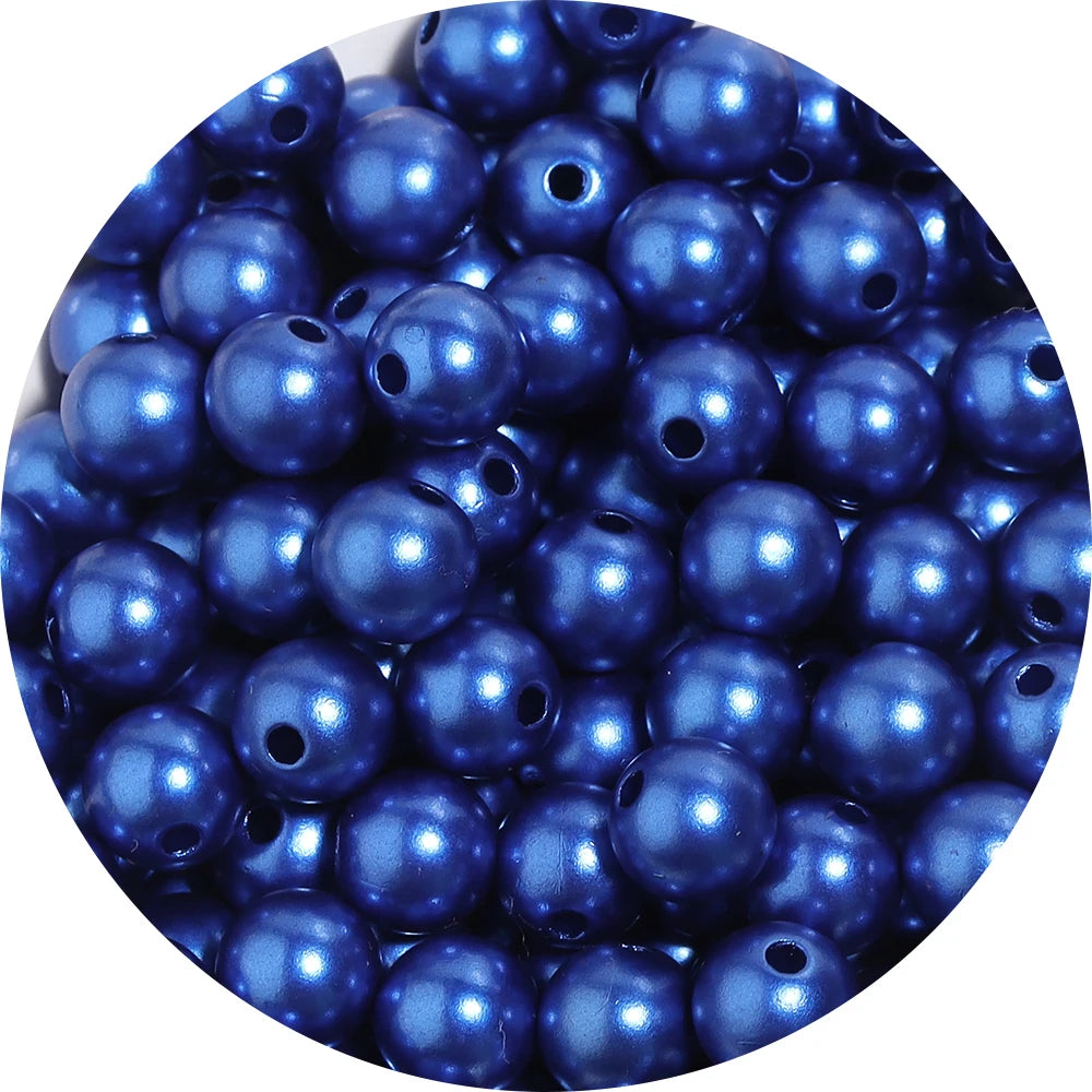 A close-up view of small, round imitation pearl beads in various shades of blue and purple.