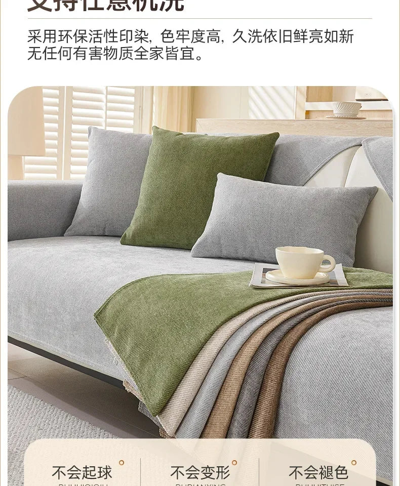 A sofa is covered with a layered, textured green and gray fabric protection cover.