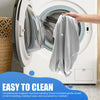 A hand is placing a gray satin zippered pillow cover into the drum of a white washing machine for cleaning.