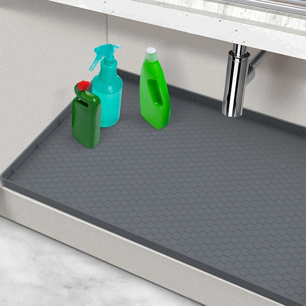 A silicone under sink drain mat with three colored bottles hanging on a kitchen or bathroom faucet.