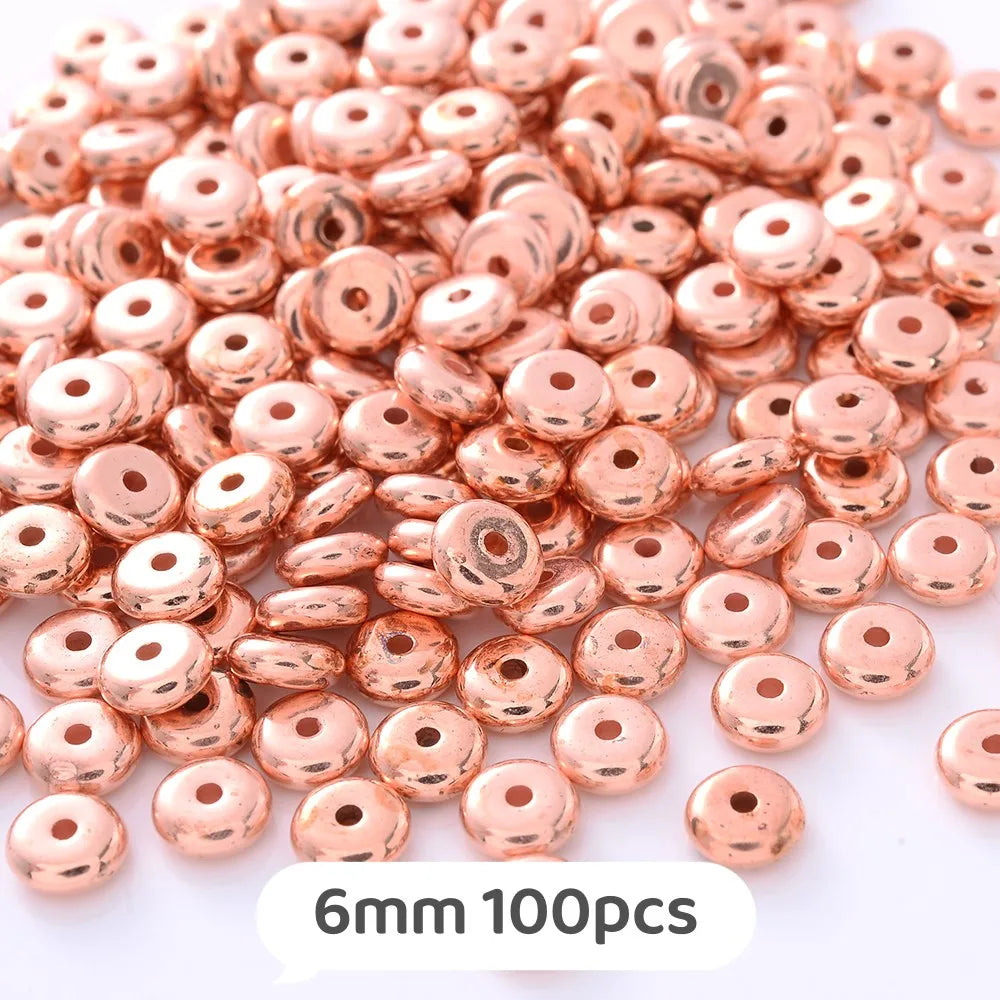 A pile of rose gold colored geometric acrylic beads for jewelry making