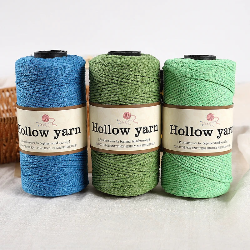 A set of three spools of hollow yarn in blue, green, and light green for knitting and crochet projects.