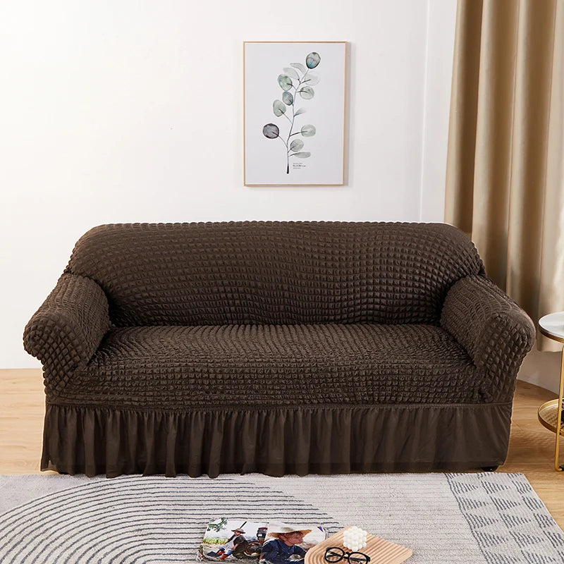 A dark brown stretch knit sofa cover with a bubble lattice texture displayed in a living room setting.