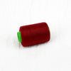 A roll of deep red sewing thread with a green core.