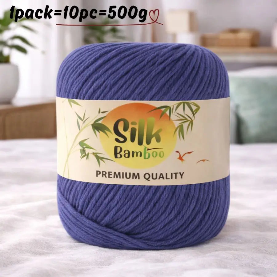 A skein of deep blue bamboo silk blend yarn is shown on a white surface.