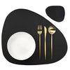 A black placemat features a white bowl and a gold fork and knife set.
