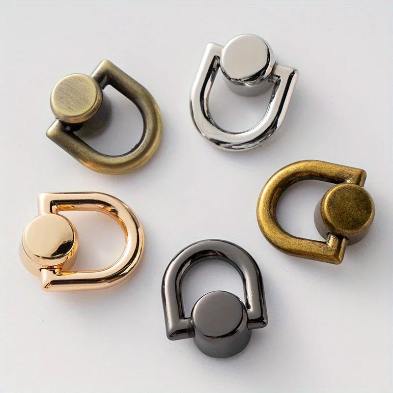 A collection of metal D-shaped ring bag handles in gold, silver, and gunmetal finishes.