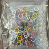 A clear plastic bag filled with various colored metal rings and buckles for fabric and accessories.