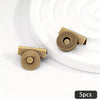 Five brass metal seamless magnetic closure buckles arranged on a white surface.