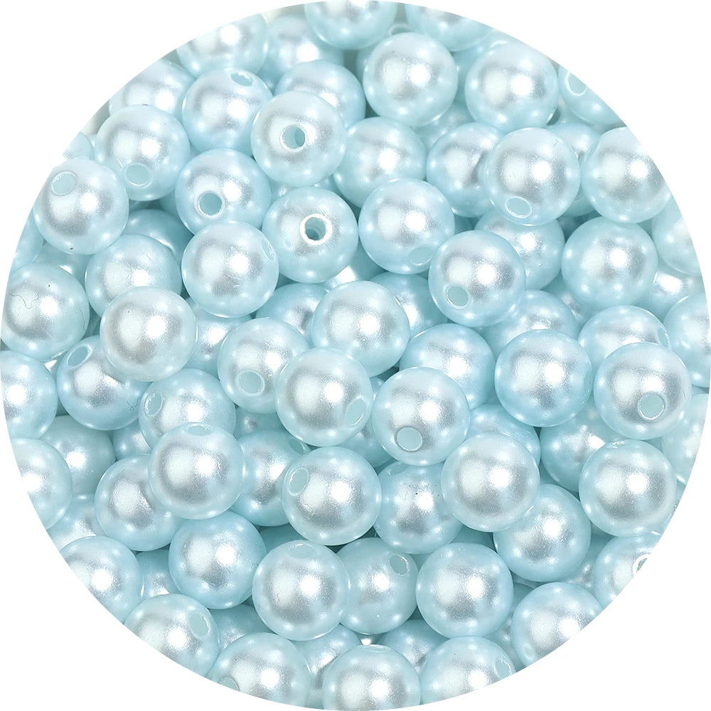 A close-up view of many small, light blue imitation pearl beads.
