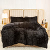 A black plush duvet cover set displayed on a bed with light beige upholstered headboards.