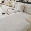 A light beige patterned jacquard sofa cover featuring a textured, branch-like design on a modern sectional sofa.