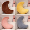 Three moon-shaped throw pillows in brown, yellow, and gray colors displayed in a retail setting.