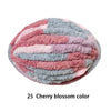 A ball of pink and blue fluffy yarn displaying a cherry blossom color pattern.