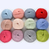 A collection of colorful premium mohair yarn skeins in various shades including red pink blue and green
